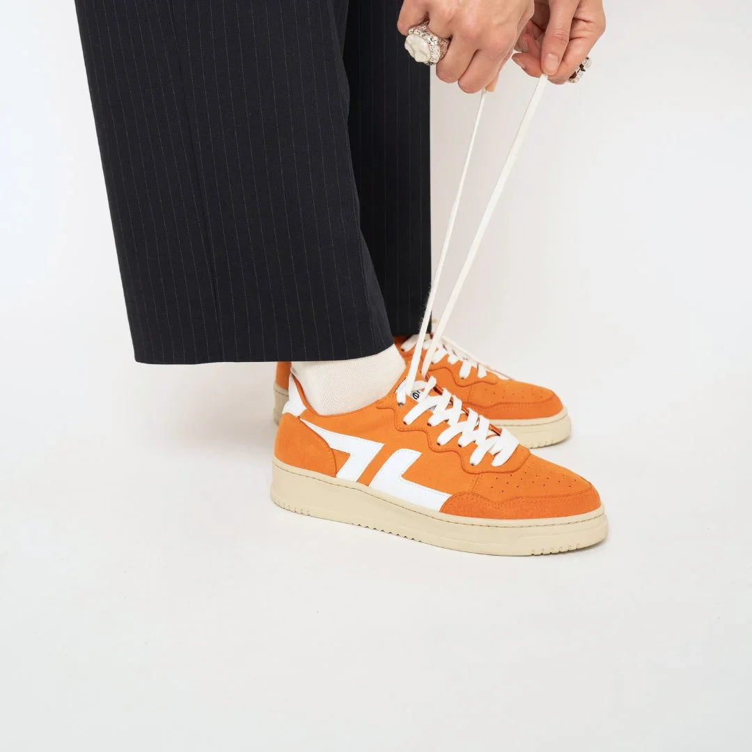 Baskets oranges Beta B3 portées, apportant dynamisme et couleur aux looks quotidiens.