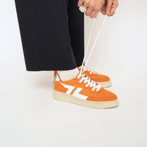 Baskets oranges Beta B3 portées, apportant dynamisme et couleur aux looks quotidiens.
