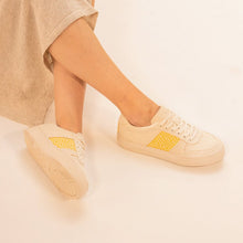 Charger l&#39;image dans la galerie, Une personne porte les baskets Mai Chau Sun Flower en toile beige avec des motifs jaunes brodés.
Les chaussures sont mises en scène dans un cadre épuré avec une tenue sobre pour un rendu naturel.