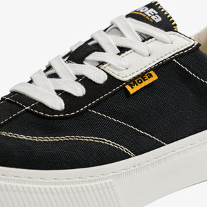 baskets en toile noire avec semelle blanche, style Vans