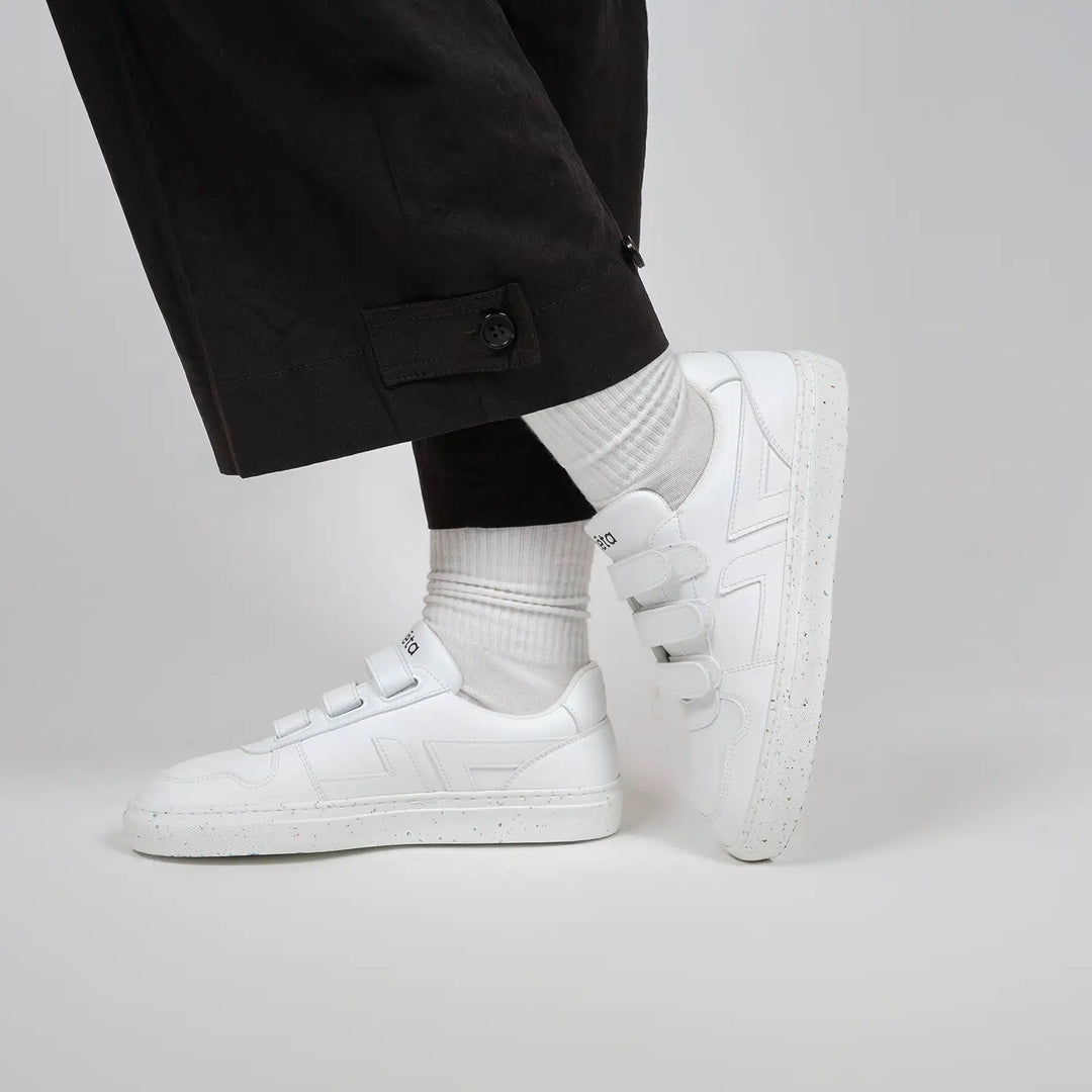 Baskets blanches Alpha Scratch en mouvement, portées avec un pantalon large noir