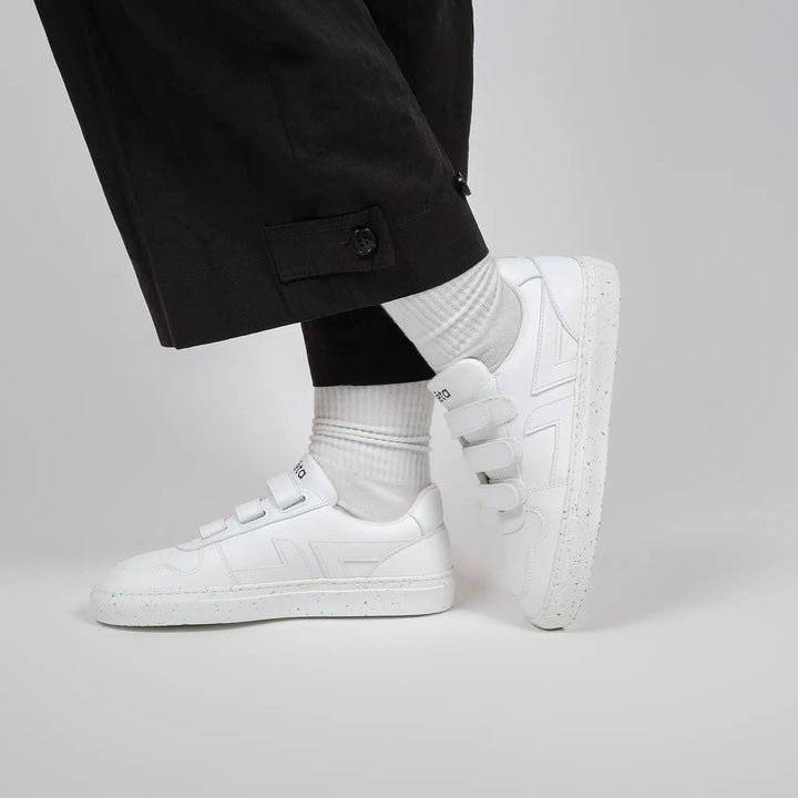 Baskets blanches Alpha Scratch en mouvement, portées avec un pantalon large noir