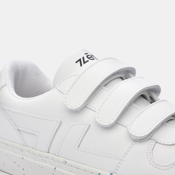 Zoom sur les baskets blanches Alpha avec fermeture à scratchs, finitions soignées et matériaux recyclés