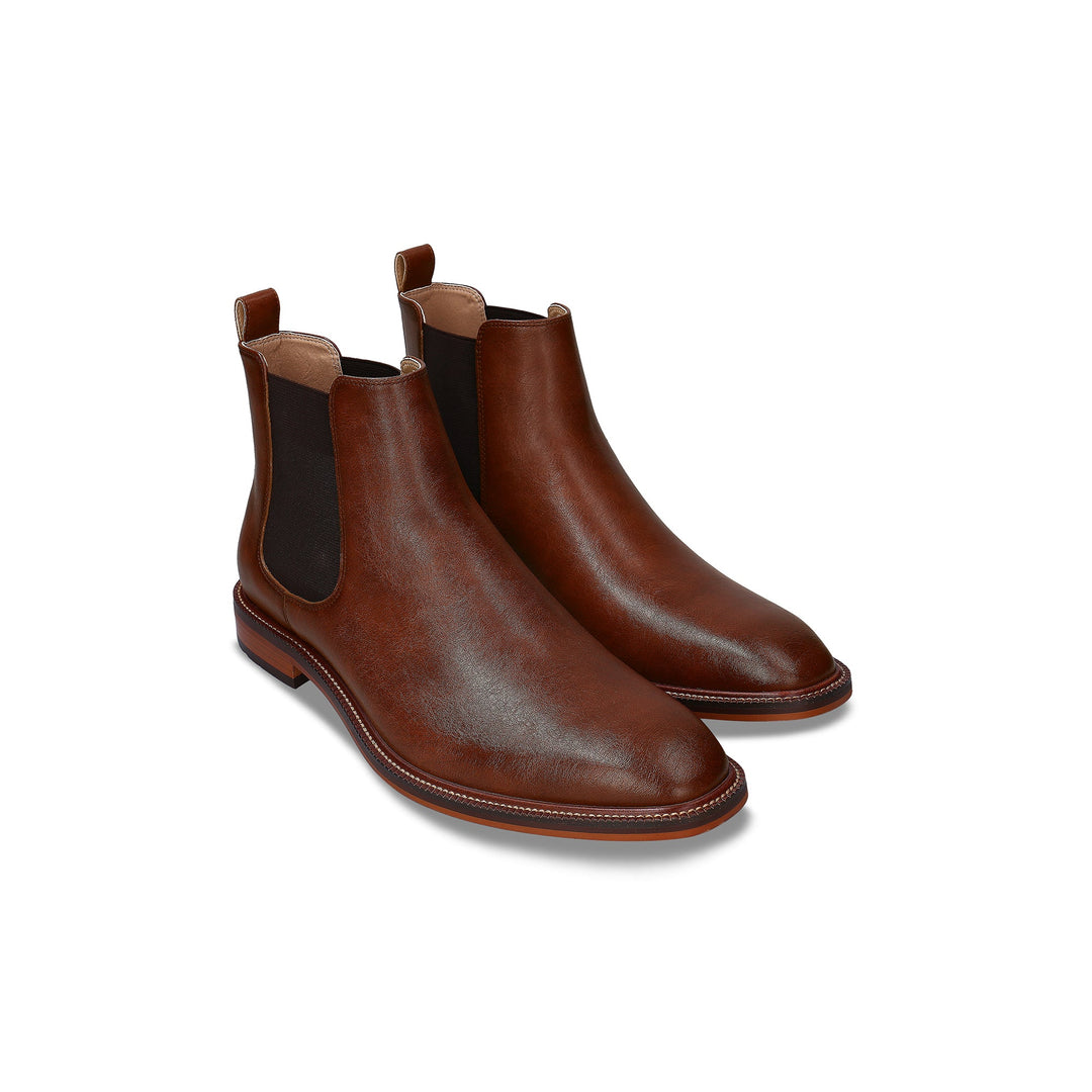 Pair of brown leather Chelsea boots on a white background