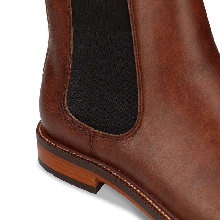 Close-up of a brown leather boot with a white background
