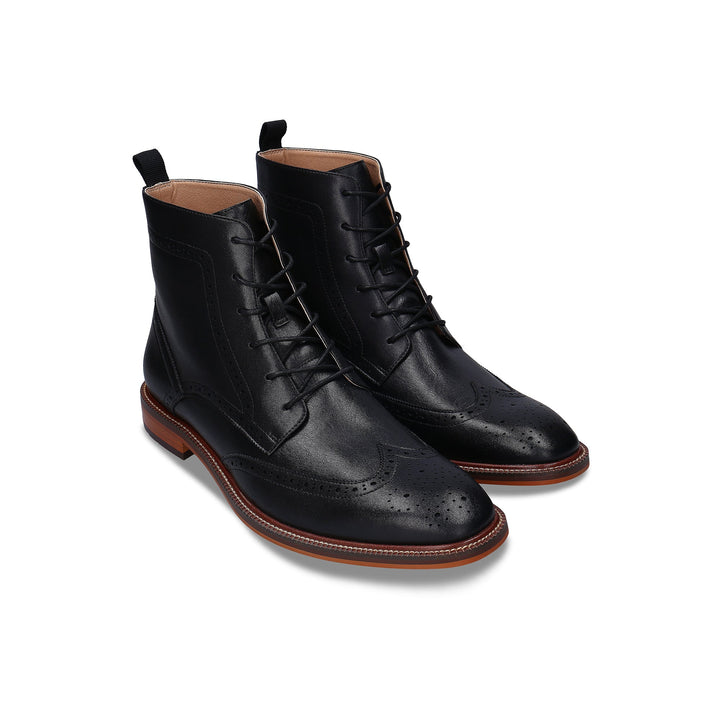 Pair of black leather dress boots on a white background