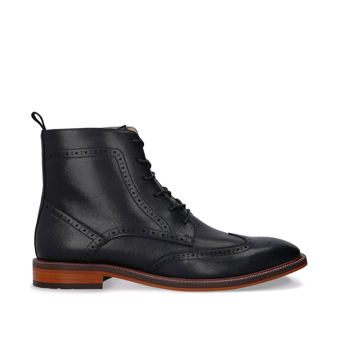 Black leather brogue boot with brown sole on a white background