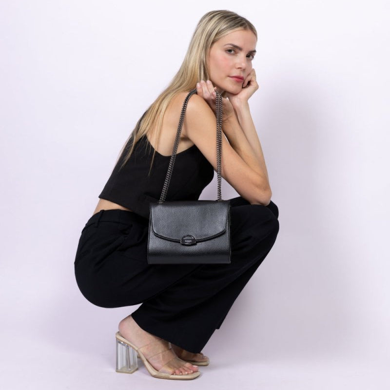 Sac à main vegan noir effet lézard porté par une femme assise, sac bandoulière Mini Paname Ashoka Paris