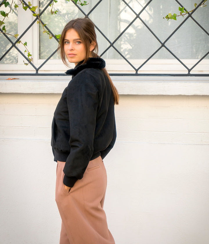 Blouson vegan pour femme, fabriqué en France. Confectionné en suédine de polyester recyclé de couleur noir, agrémenté de fausse fourrure, ce blouson est conçu à Paris. Explorez notre gamme de vêtements vegan, notamment nos manteaux écologiques et écoresponsables pour femme. Chaque pièce est fabriquée dans le respect de conditions éthiques, en utilisant des matières provenant d&